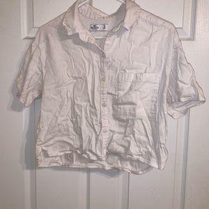 This white cropped button up t-shirt is from Hollister. It is a size small.